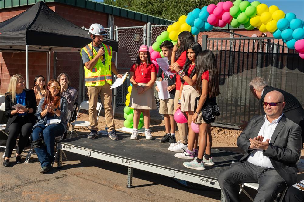 Galveston Elementary School student council members stand on stage with principal Tony Alcala